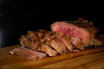 Closeup of grilled sirloin steak on a wooden cutting board