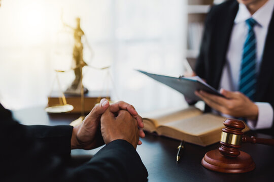 male lawyer discuss to a legal document explaining the terms of a consultation with a businessman. before signing a contract with a law firm.