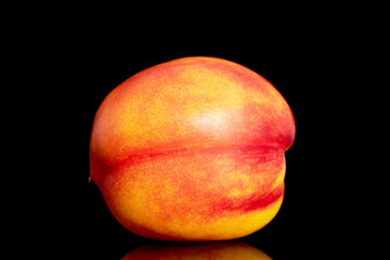 One ripe juicy nectarine, close-up, isolated on a black background.