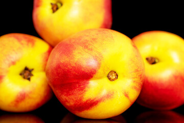 Several sweet organic nectarines, close-up isolated on a black background.