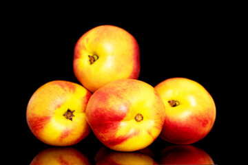 Several sweet organic nectarines, close-up isolated on a black background.