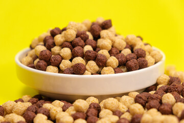 Corn sweet balls on a yellow background. Quick dry breakfasts, side view.