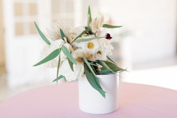 Elegant white floral centerpiece on pink table 