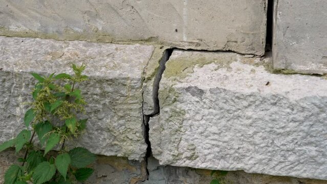 Fracture in a concrete wall. Fissure of cracked building close-up. Housing destruction