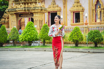 Beautiful Asian girl at big Buddhist temple dressed in traditional costume