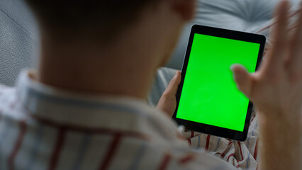 Closeup hand scrolling tablet making video call. Unknown man waving green screen