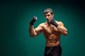 Side view of Male boxer training and practicing swing Isolated on green studio background. Concept...