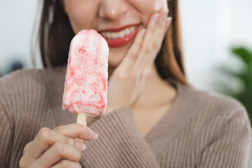 Fototapeta Asian Woman touching her chin feeling sensitive teeth when eating an ice cream. Have a gum and oral problem. obraz