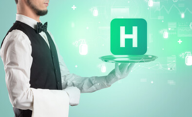 Handsome young waiter in tuxedo holding healthcare icons on tray
