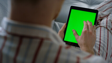 Businessman swiping mockup tablet at home closeup. Green screen template device