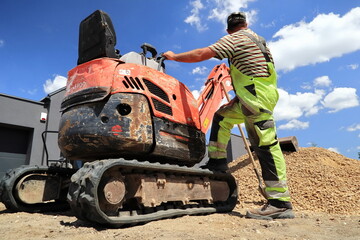 The excavator operator gets to work. - obrazy, fototapety, plakaty