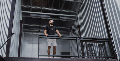 A young man in t-shirt and shorts on the stairs at city streets