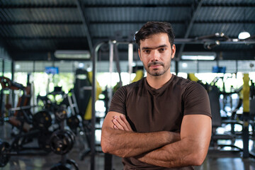 Fototapeta na wymiar Portrait of man standing arms crossed after exercises at fitness gym.Male workout for good health concept.