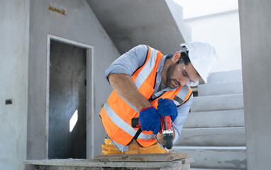 Adult American Hispanic male engineer builder renovating with drill in mask helmet and...