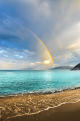 Spectacular rainbow behind a crystal clear sea