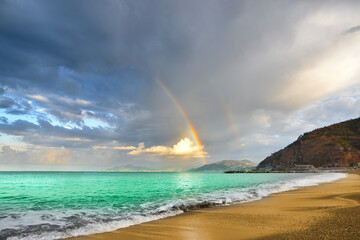 Spectacular rainbow behind a crystal clear sea
