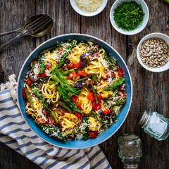 Fettuccine with asparagus, parmesan and pepper on wooden table