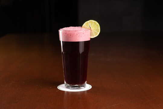 Chicha Morada con fondo negro en una mesa de madera, bebida t&iacute;pica del Per&uacute;.
