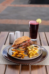 Sandwich de carne en un plato en la mesa de un restaurante.