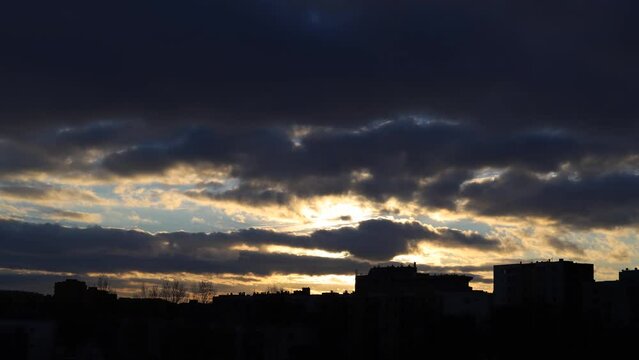 miasto, zach&oacute;d słońca nad budynkami za chmurami, time laps