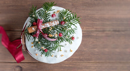 German Christmas cake on wooden table with festive decorations. Dresdnen Stollen is a Traditional German Cake with raisins. Gift for Christmas.