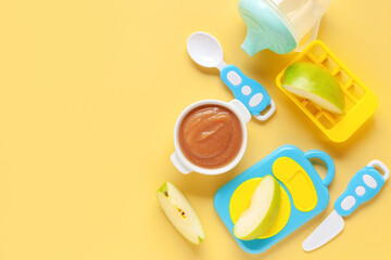 Apple puree in a bowl and toy plastic tableware. Baby food concept. Top View