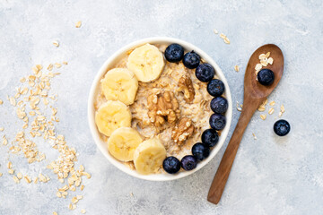 Oatmeal porridge with walnuts, blueberries and bananas - healthy rustic breakfast