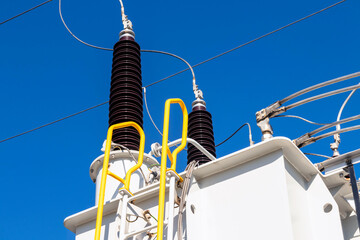 Various high voltage electrical insulators in a substation against a blue sky
