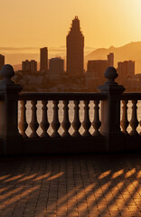 View of the city of Benidorm in the setting sun, sunset, selective focus on the shadow of the balustrade in the foreground.