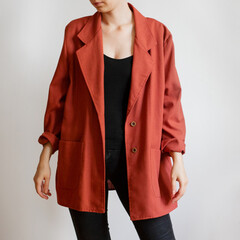 Woman wearing oversized red blazer and black jeans isolated on white background