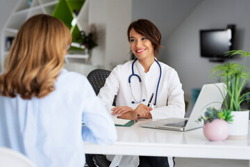 Female doctor consulting with her patient at the doctor's office - 513374163
