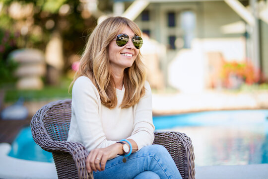 Confident Middle Aged Woman Relaxing At The Backyard At Home