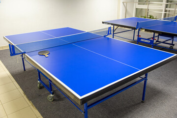 Two blue ping pong tables in the room