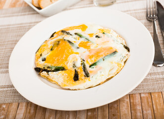 Closeup of fried eggs with asparagus at plate