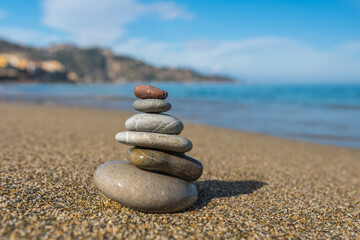 Stones balance on beach in Giardini Naxos, Sicily.