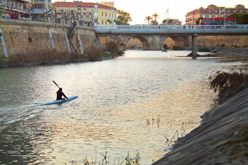 Young canoeist trains with his canoe plying the waters of the Segura River as it passes through Murcia