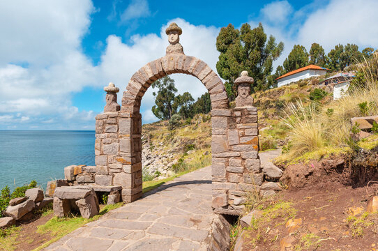 Walking path on Taquile Island with arch of the elder and view over Titicaca Lake, Peru.