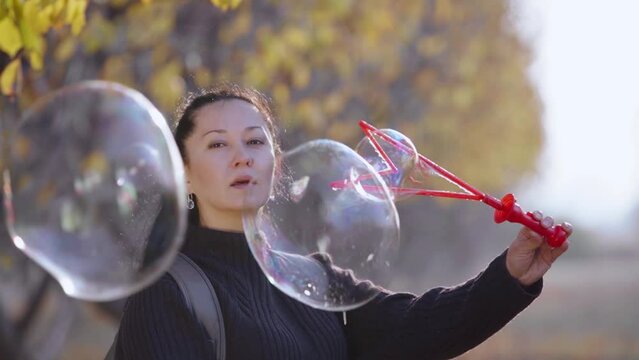 the girl laughs and blows soap bubbles