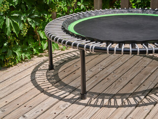 detail of mini trampoline for fitness exercising and rebounding in a backyard patio with shadow