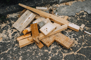 Background, close-up texture of sawn wooden boards, bars with sawdust after a sawmill on asphalt. - obrazy, fototapety, plakaty
