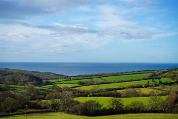 Fototapeta na wymiar View over the countryside and ocean with blue skies