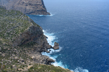 View down on waves crashing against coastal cliffs at Mirador Es Colomer Formentor, Mallorca, Spain
