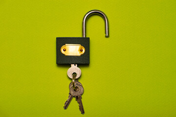 an open padlock with inserted keys on a green background