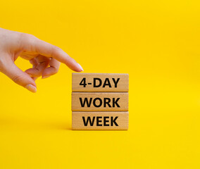 4-day work week symbol. Concept words 4-day work week on wooden blocks. Beautiful yellow background. Businessman hand. Business and 4-day work week concept. Copy space