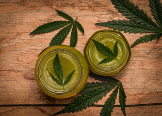 New fresh marijuana salve in glass on old wooden table