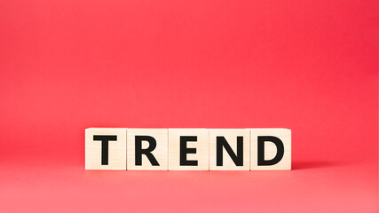 Trend symbol. Concept word Trend on wooden cubes. Beautiful red background. Business and Trend concept. Copy space.