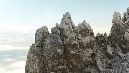 Close up for sharp rock formation on blue, cloudy sky background. Shot. Aerial for sharp peaks of...