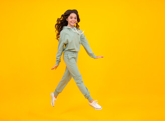 Fototapeta na wymiar Sporty teenager child wearing a casual sport look. Cute teen girl in sports suit posing over yellow background.