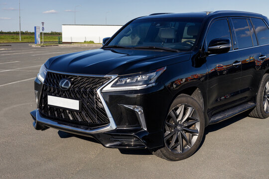 Samara, Russia - 05.30.2022: New LEXUS LX 570 in dark blue color. The car is in an empty parking lot. The car is parked on an asphalt road. Shooting on a clear, sunny day. The front part