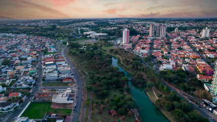 Fototapeta premium Indaiatuba Ecological Park. Beautiful park in the city center, with lake and beautiful trees and houses. Aerial view